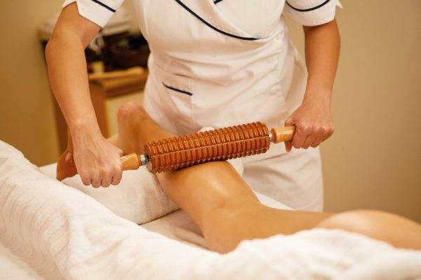 unrecognizable-therapist-performing-maderotherapy-woman-s-legs-during-massage-treatment-spa-2